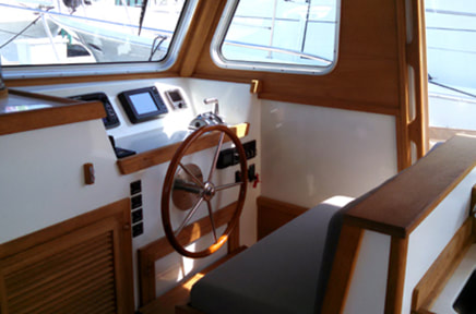 Cabin and wooden steering wheel of twist wooden downeast power yacht boat refit and restored by south shore boatworks
