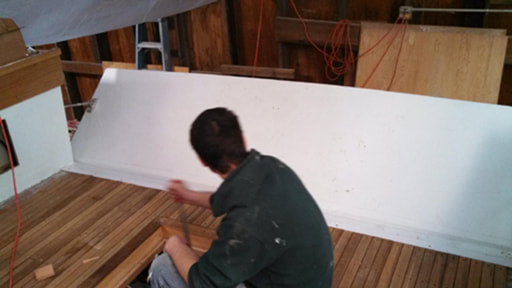 South shore boatworks restoring and refitting the teak deck of twist downeast power yacht boat in shop