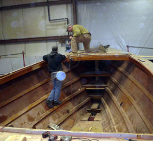 South shore boatworks restoring and reffting the forward deck of wooden twist downeast power yacht boat in shop