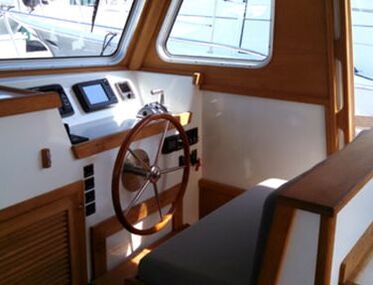 interior of a downeast wooden yacht refit and restored by south shore boatworks highlighting a teak rim steering wheel