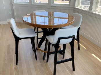 wooden nautical table with compass rose inlay built by south shre boatworks surrounded by chairs in a dining room