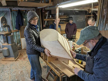 student flipping over a plymouth rock'r wooden rocking boat in a class taught by Bob fuller and south shore boatworks