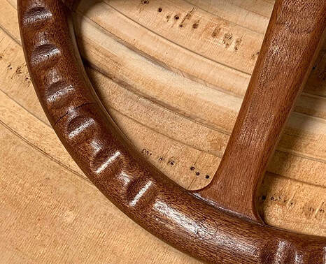 detail of wooden finger grips on wooden powerboat steering wheel built by south shore boatworks for yachts ships and boats