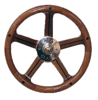 front of wooden steering wheel with bronze hub built by south shore boatworks with teak finger grips in performance plus design for powerboats