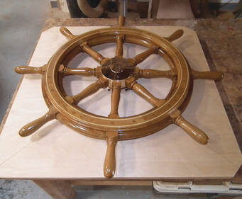 Finished yacht boat wooden steering wheel on shop bench with varnished finish by south shore boatworks