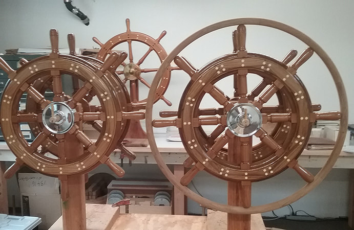 varnished wooden teak steering wheels with holly bungs and rim with chromed bronze hub built by south shore boatworks for Edson marine